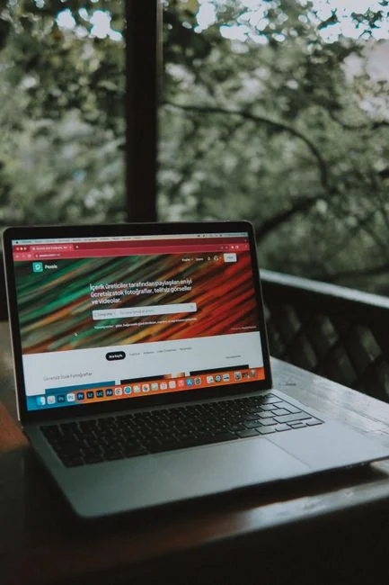 Dual monitors on a desk, showcasing web design in a modern office setting.